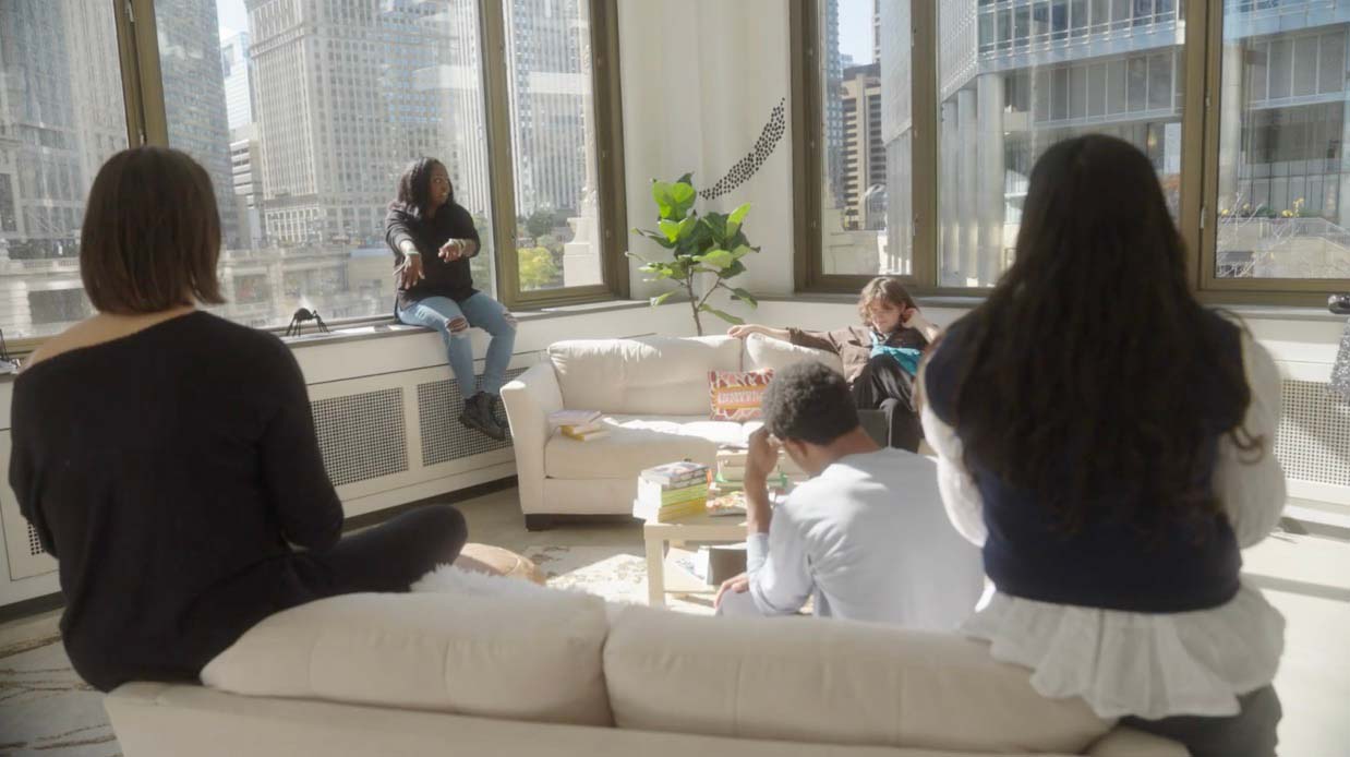 Danielle chatting with customers on couch.