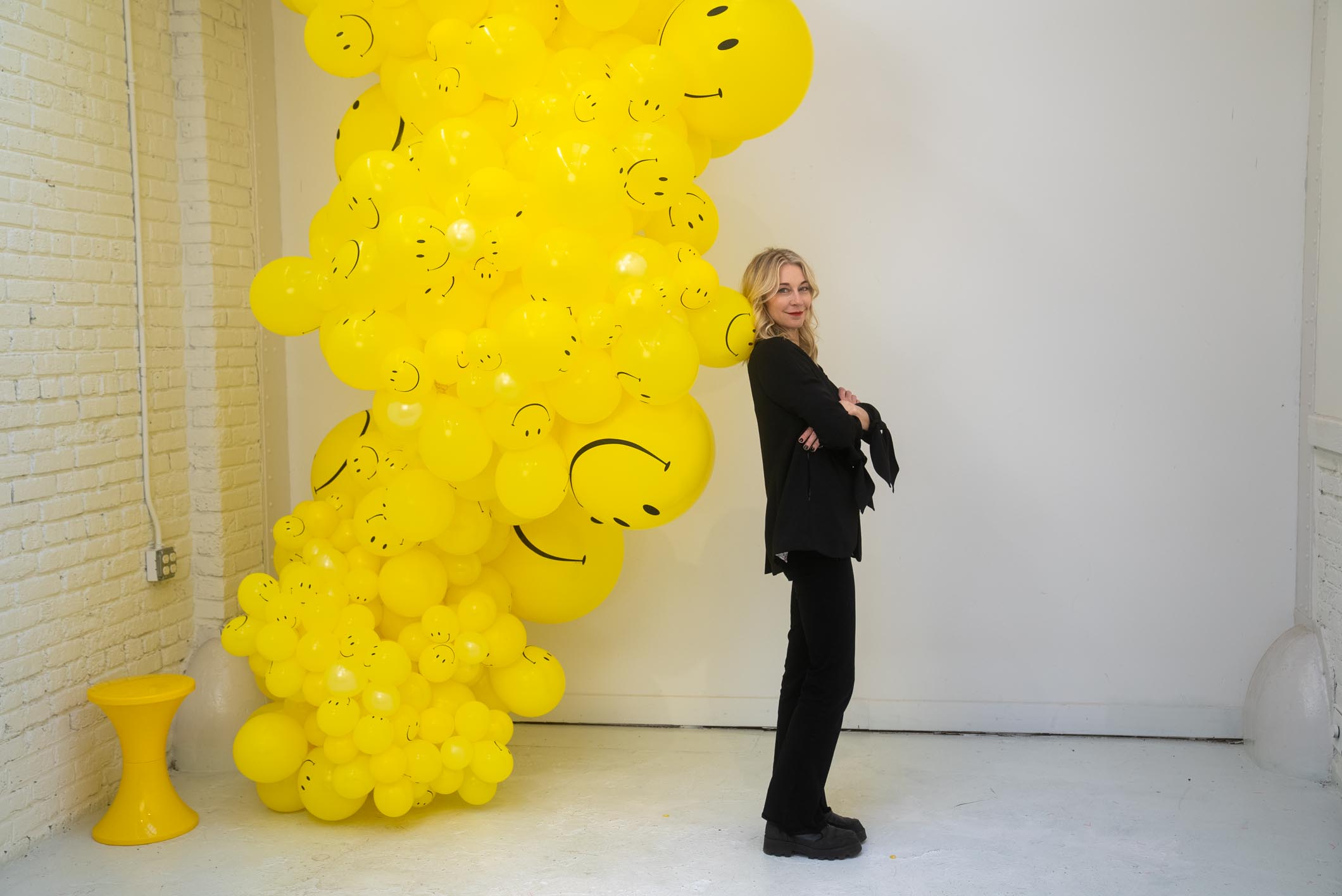 Elaine standing next to the balloons with smiley face