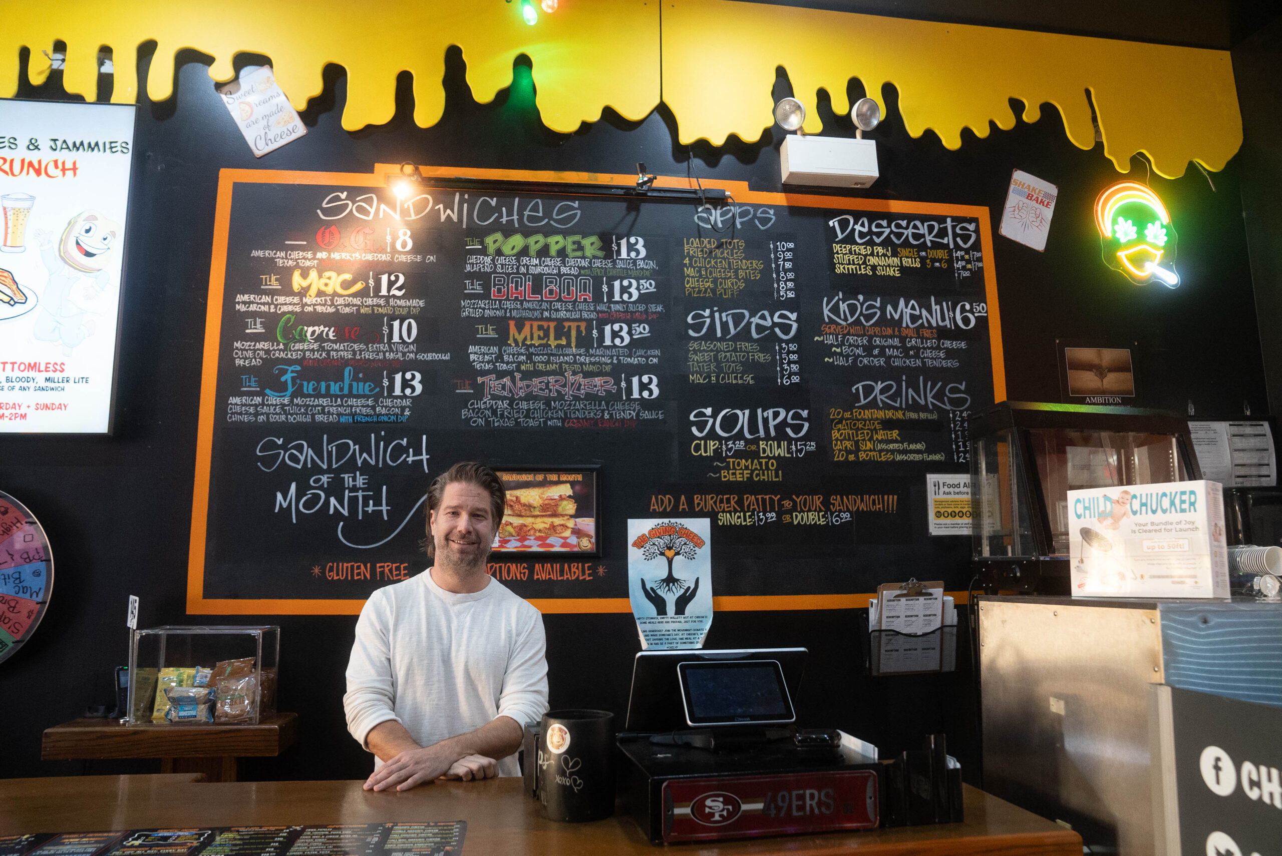 Owner Chris Johnston standing in front of the menu