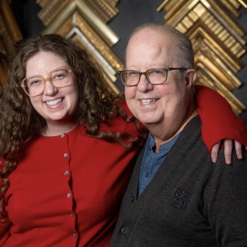 Cece and Jim Callihan smiling togeter in front of the frames.